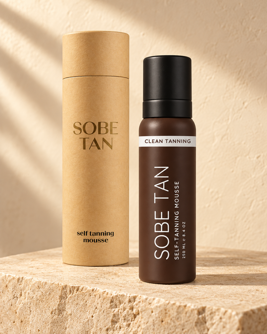 SoBe Tan Self-Tanning Mousse bottle and kraft tube on warm travertine
