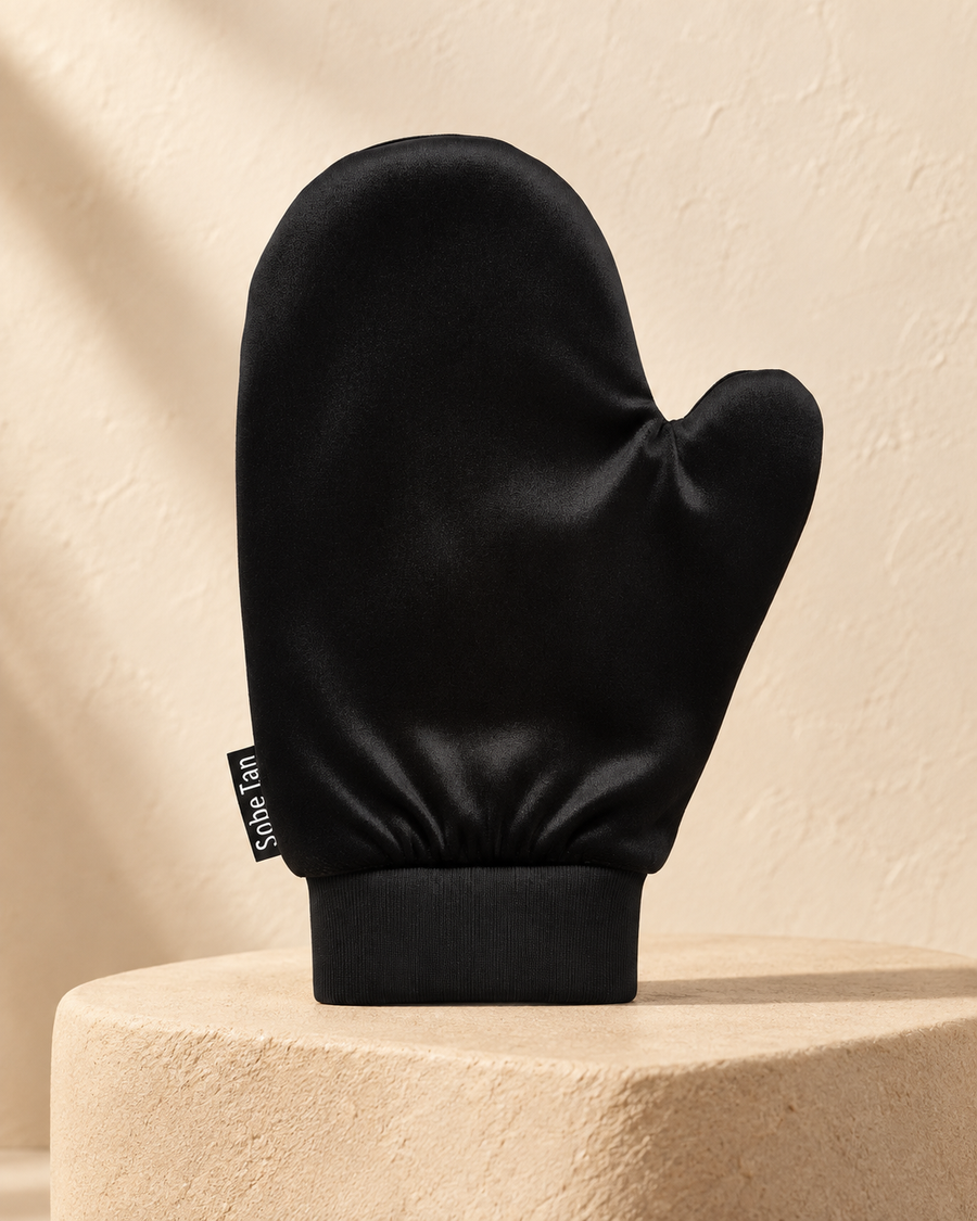 SoBe Tan self-tanning mitt standing on warm stone